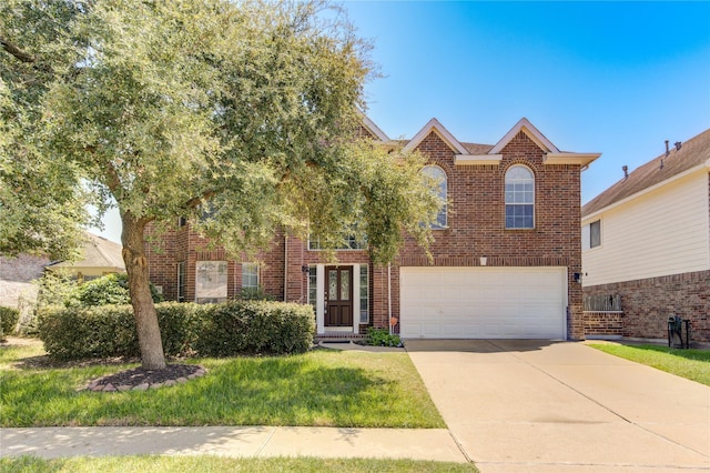 traditional-style home with a front lawn, concrete driveway, brick siding, and an attached garage