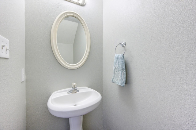 bathroom with a sink and a textured wall