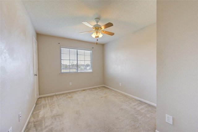 carpeted empty room with ceiling fan, a textured ceiling, and baseboards