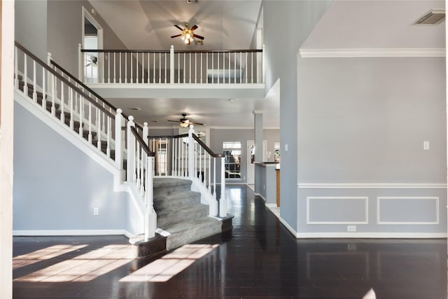 foyer with visible vents, ceiling fan, stairway, wood finished floors, and crown molding