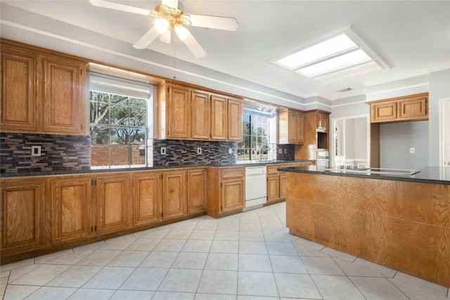 kitchen with dark countertops, black electric cooktop, brown cabinets, and dishwasher