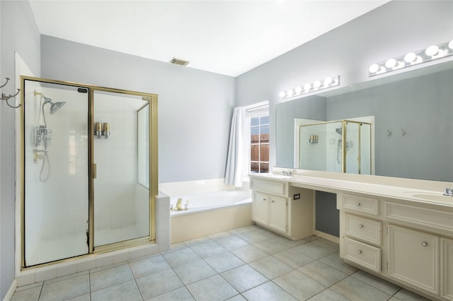 bathroom featuring a stall shower, a garden tub, vanity, and tile patterned floors