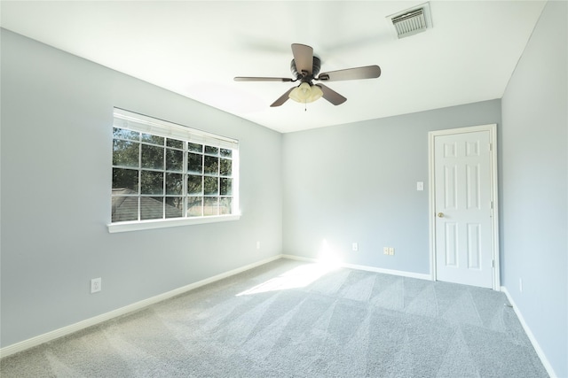 carpeted empty room featuring baseboards, visible vents, and ceiling fan