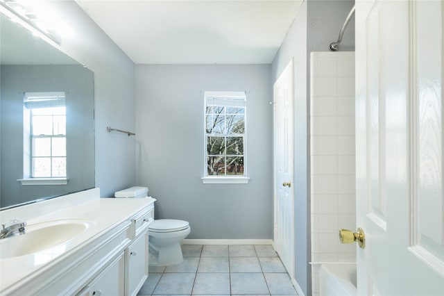 bathroom with a wealth of natural light, vanity, toilet, and tile patterned floors