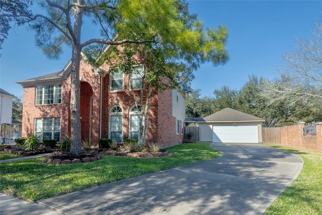 view of front of house featuring brick siding, a detached garage, a front lawn, and fence