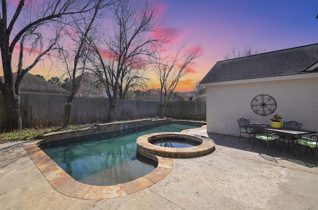 view of pool featuring a pool with connected hot tub, a fenced backyard, and a patio area