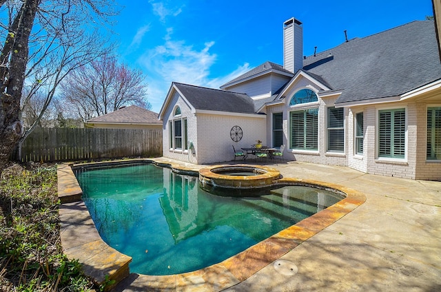 view of pool with a pool with connected hot tub, a patio, and fence