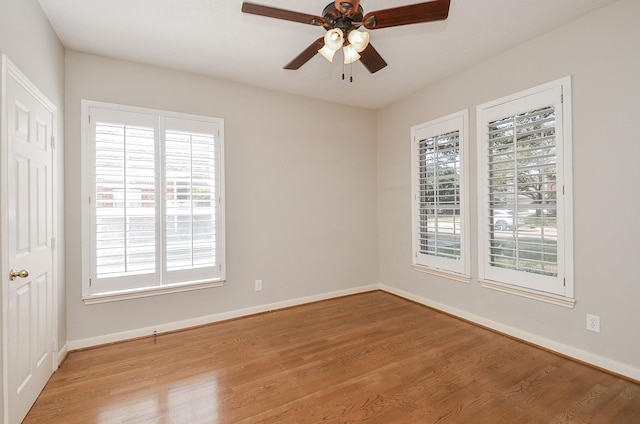 unfurnished room with baseboards, ceiling fan, and wood finished floors