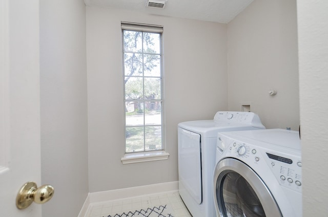 washroom featuring a wealth of natural light, baseboards, separate washer and dryer, and laundry area