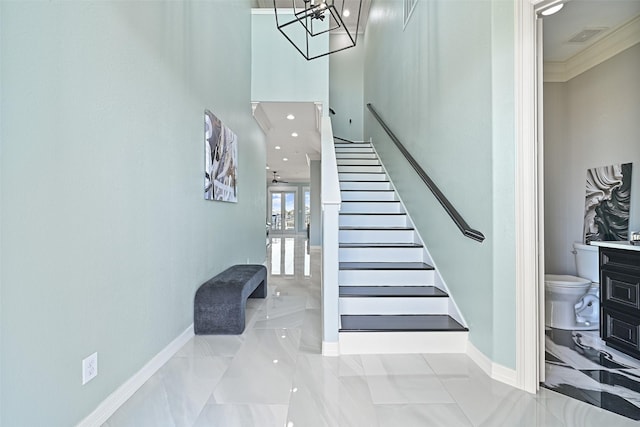 stairway featuring marble finish floor, crown molding, visible vents, a chandelier, and baseboards