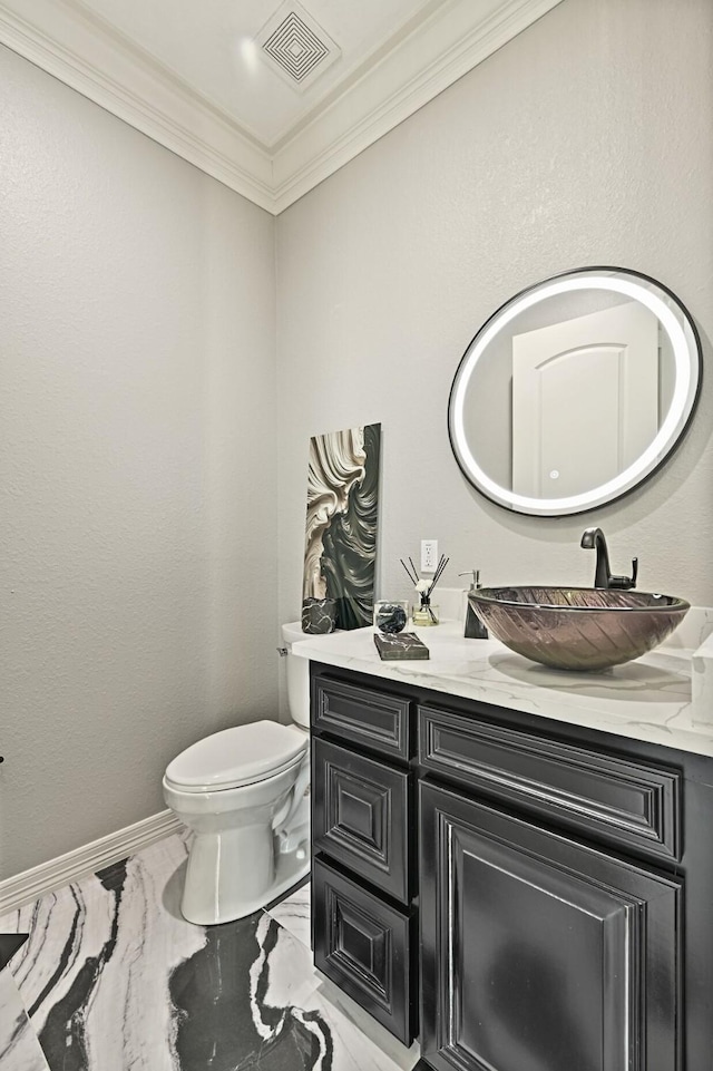 half bathroom featuring visible vents, baseboards, toilet, ornamental molding, and vanity