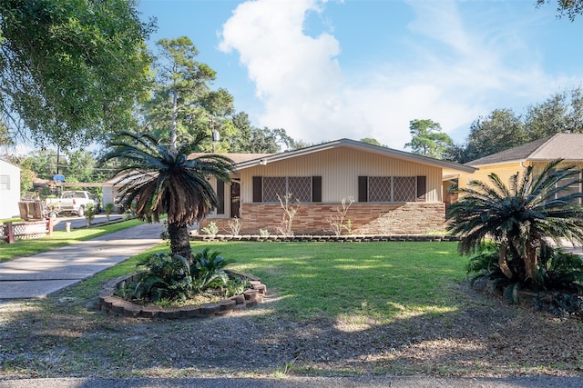 view of front of home with driveway, brick siding, and a front yard