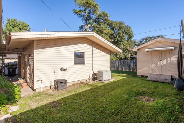 view of property exterior with a storage unit, fence, an outdoor structure, and a yard