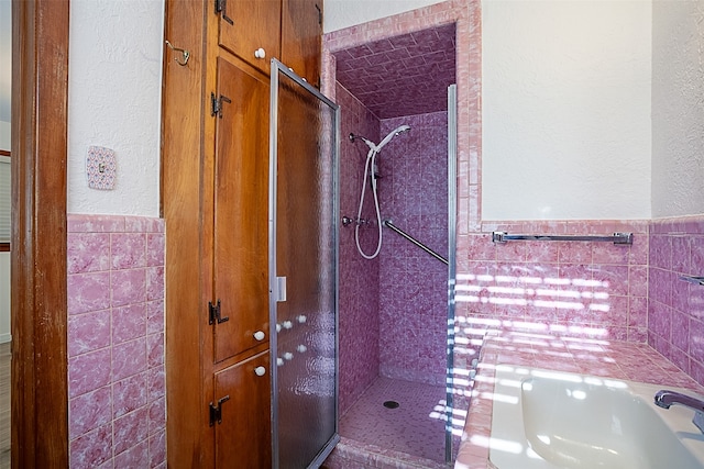 full bathroom with a bath, a stall shower, and tile walls