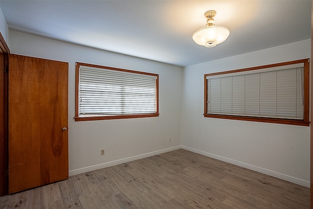 unfurnished bedroom with wood finished floors and baseboards