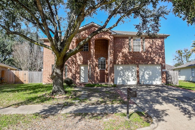 traditional-style house with brick siding, an attached garage, fence, driveway, and a front lawn