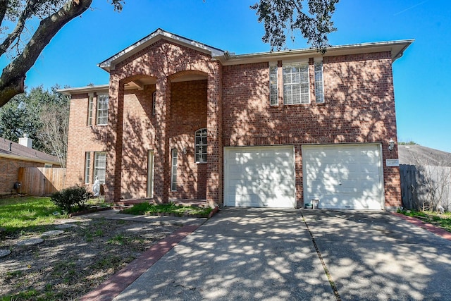 traditional-style home featuring an attached garage, fence, concrete driveway, and brick siding