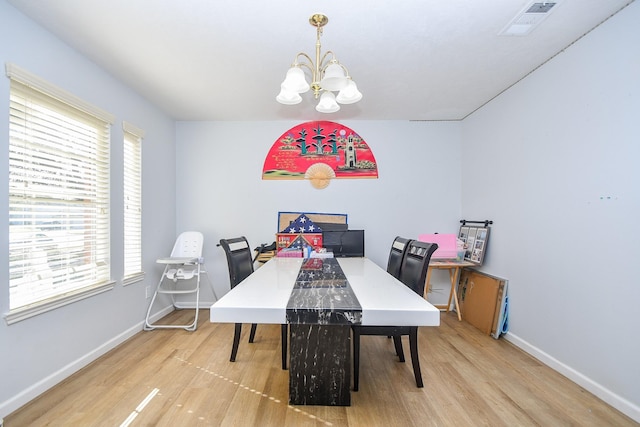 dining room with a notable chandelier, baseboards, and wood finished floors