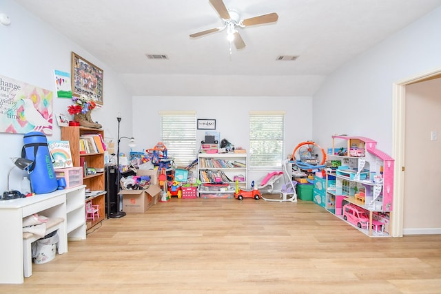 rec room with lofted ceiling, light wood-style floors, and visible vents