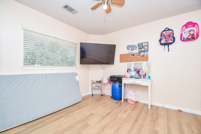 bedroom featuring a ceiling fan, visible vents, baseboards, and wood finished floors