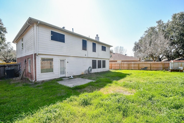 back of property with a fenced backyard, central AC, brick siding, a yard, and a patio area