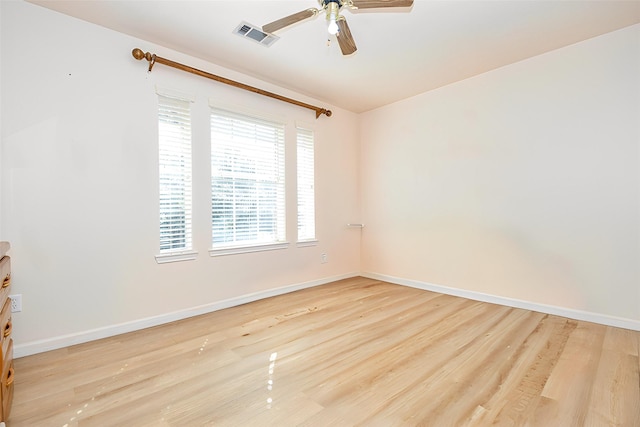 unfurnished room with baseboards, a ceiling fan, visible vents, and light wood-style floors