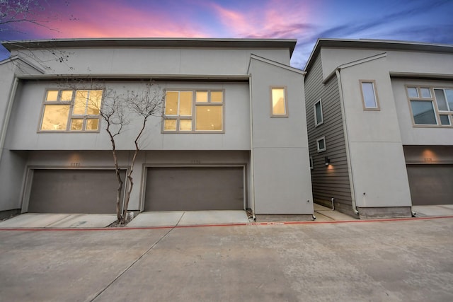 view of front of home featuring a garage, driveway, and stucco siding