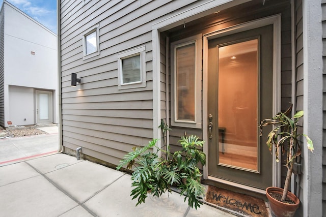 view of exterior entry with a patio