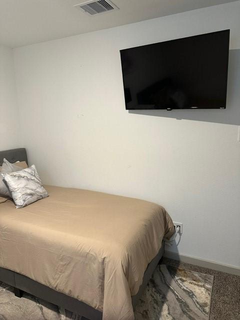 carpeted bedroom featuring baseboards and visible vents