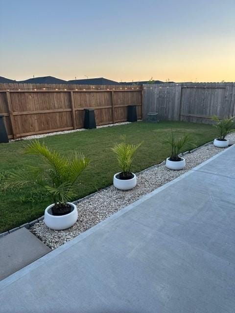 yard at dusk with a fenced backyard