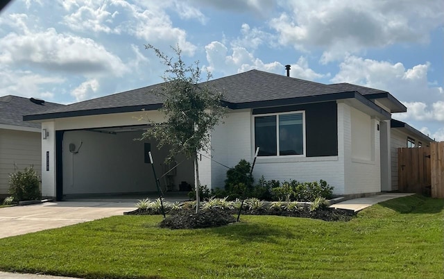 ranch-style home with a garage, driveway, a shingled roof, a front lawn, and brick siding