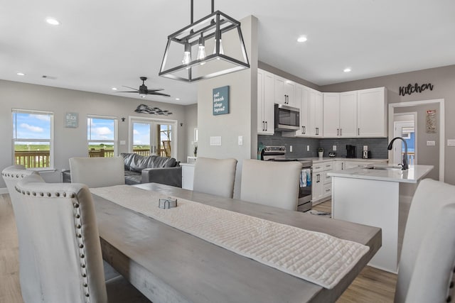 dining area featuring light wood-type flooring, recessed lighting, and a healthy amount of sunlight