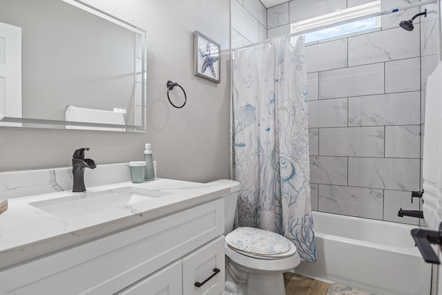 bathroom featuring a textured wall, toilet, wood finished floors, vanity, and shower / tub combo with curtain