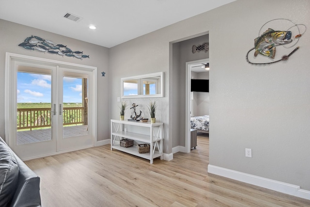 doorway with light wood-style flooring, visible vents, and baseboards