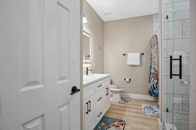 full bathroom featuring baseboards, toilet, wood finished floors, vanity, and a shower stall