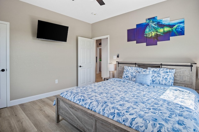 bedroom with ceiling fan, light wood-style flooring, and baseboards