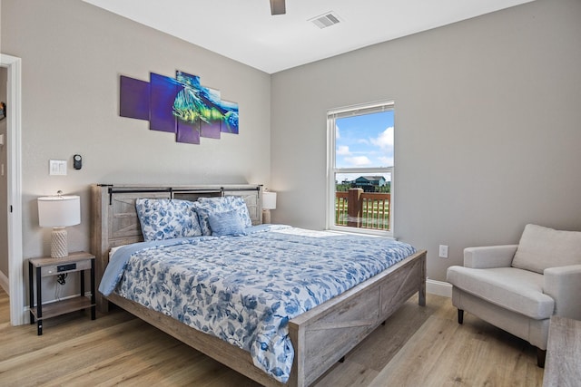 bedroom featuring light wood finished floors, baseboards, visible vents, and ceiling fan