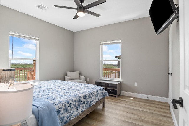 bedroom with ceiling fan, light wood-type flooring, visible vents, and baseboards