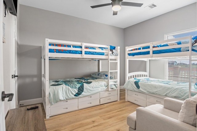 bedroom featuring wood finished floors, visible vents, and a ceiling fan