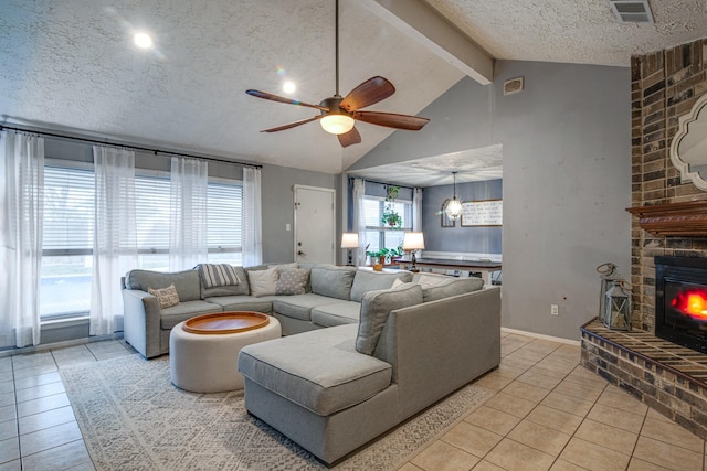 living room with visible vents, vaulted ceiling with beams, a fireplace, light tile patterned flooring, and a textured ceiling