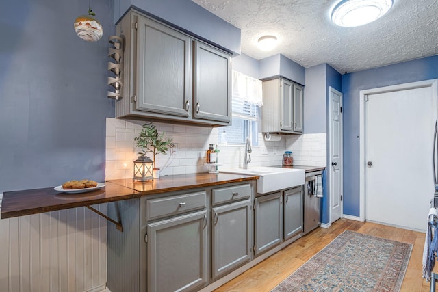 kitchen with gray cabinets, light wood-type flooring, and a sink