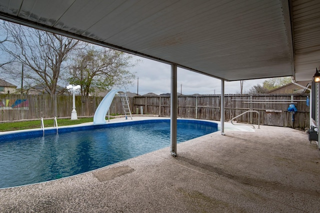 view of pool with a fenced in pool, a patio area, a fenced backyard, and a water slide