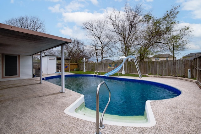 view of pool featuring a fenced in pool, a water slide, a storage shed, an outdoor structure, and a fenced backyard