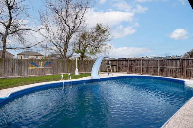 view of swimming pool with a fenced in pool, a water slide, and a fenced backyard