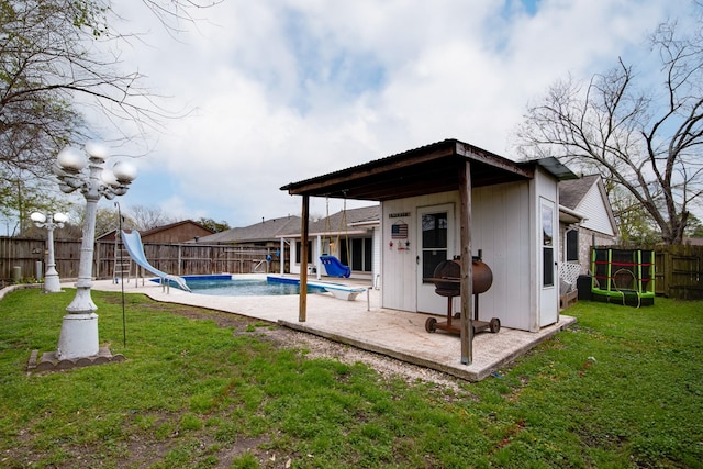 rear view of property with a patio, a yard, a fenced backyard, and a fenced in pool