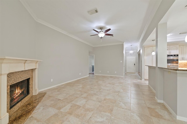 unfurnished living room featuring ceiling fan, visible vents, baseboards, a high end fireplace, and crown molding