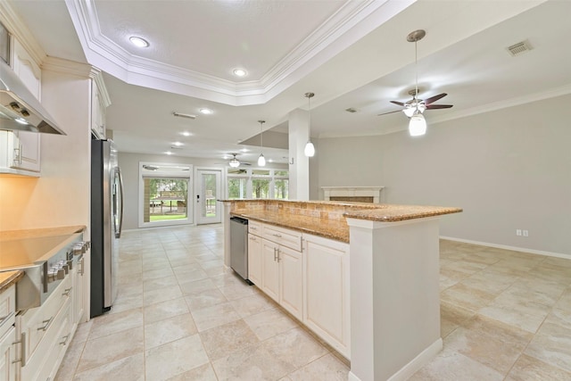 kitchen featuring under cabinet range hood, visible vents, open floor plan, appliances with stainless steel finishes, and a tray ceiling