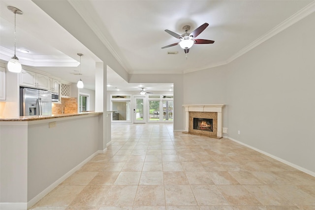 unfurnished living room with visible vents, baseboards, a ceiling fan, ornamental molding, and a fireplace