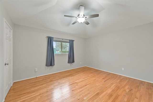 spare room with a ceiling fan, light wood-type flooring, and baseboards