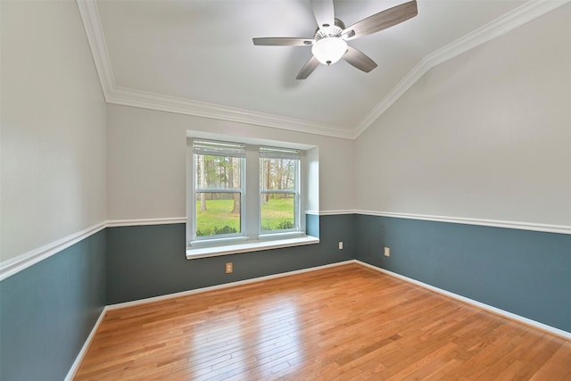 spare room featuring baseboards, lofted ceiling, wood-type flooring, ceiling fan, and crown molding